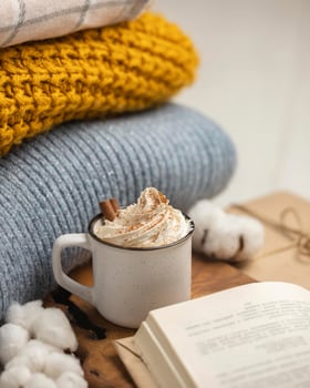 high-angle-cup-coffee-with-whipped-cream-cinnamon-sticks