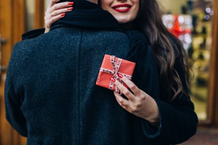 woman-with-gift-box-embracing-man