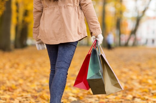 woman-with-shopping-bags-walking-along-autumn-park